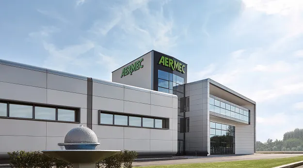 Modern industrial building with the AERMEC signage, glass entry, and gray panels against a blue sky.
